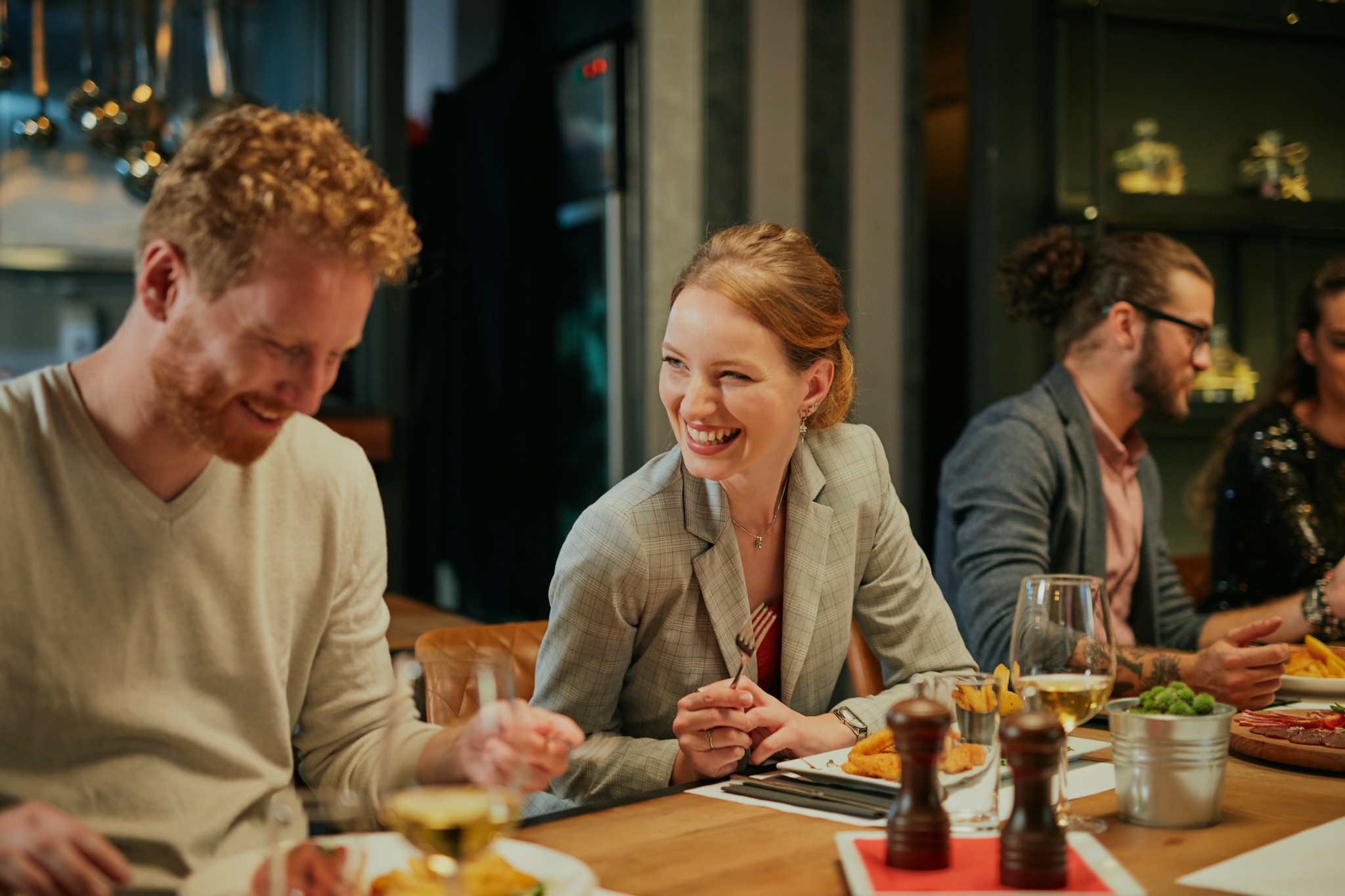 Photo of happy guests chatting and smiling at a restaurant.