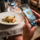 Photo of guest taking a photo of her fine dining dish at a restaurant